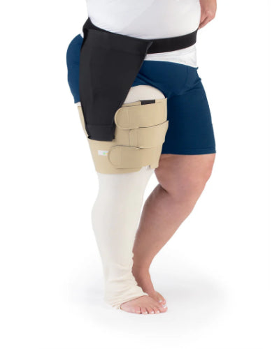 Person wearing the Sigvaris Reduce Thigh compression wrap to help remove swelling in the thigh portion of their right leg in the color beige