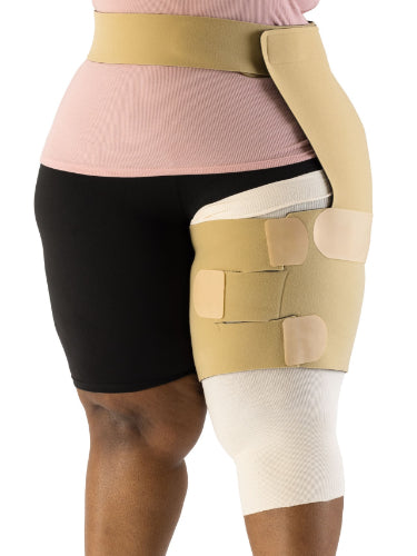 Lady wearing the Sigvaris Contain Thigh Compression Velcro Wrap with hip attachment on her left leg in the color beige