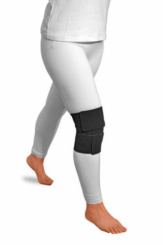 A person wearing light gray leggings wearing the black Solaris ReadyWrap Knee velcro wrap to control lymphedema swelling.