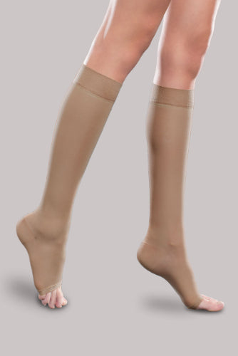 Lady wearing her Ease Sheer Open Toe Knee High 15-20 mmHg compression stocking by Therafirm in the color sand