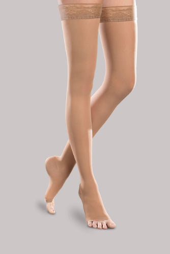 Lady wearing her Ease Sheer 20-30 mmHg compression thigh-high open-toe stocking by Therafirm in the color sand