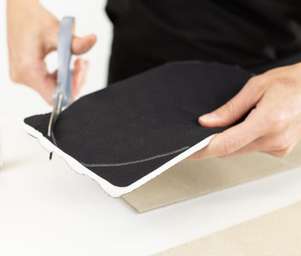 person trimming the Circaid TEC foam pad to use in the decongestion of a lymphatic limb