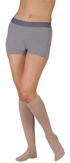 Woman wearing her Juzo Dynamic Closed Toe Knee High 30-40 mmHg Compression Stockings with 3.5 cm Silicone Dot Band in the color Beige