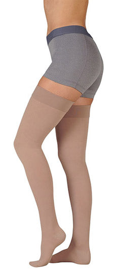 Lady wearing Juzo Dynamic 40-50 mmHg Closed Toe Thigh High with Silicone Dot Band in the color Beige