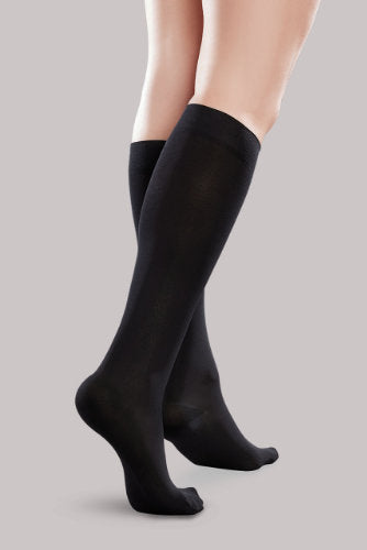 Lady's leg wearing the Ease Microfiber compression stocking by Therafirm in the color Black