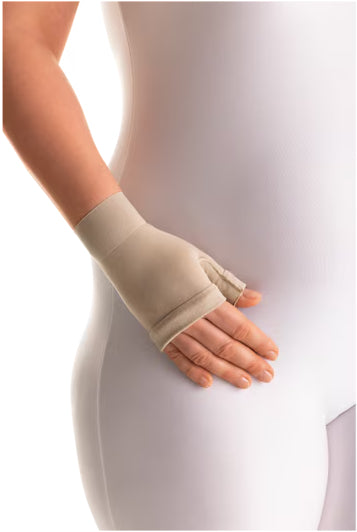 lady wearing a white jumpsuit has a Jobst Bella Lite 15-20 mmHg Compression gauntlet on her hand. 