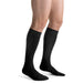 Guy wearing his Jobst for Men Ambition SoftFit 15-20 mmHg Knee High compression socks in the color black.