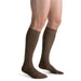 Guy wearing his Jobst for Men Ambition SoftFit 15-20 mmHg Knee High compression socks in the color brown.