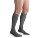 Guy wearing his Jobst for Men Ambition SoftFit 15-20 mmHg Knee High compression socks in the color grey.