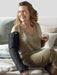Lady smiling while wearing her Juzo Night Nighttime Lymphedema Sleeve wile sitting on her bed