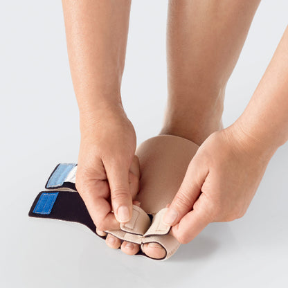 Lady velcroing her toes with the Lohmann and Rauscher Toe wrap in the color beige.