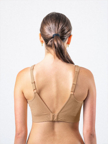 Woman facing away showing the back side of her Prairie Wear Hugger ARIA compression bralette in the color Fawn.