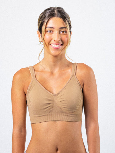 Woman wearing her Prairie Wear Hugger ARIA compression bralette in the color Fawn against a white background
