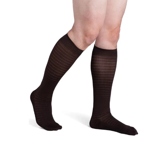 Male wearing his Sigvaris Microfiber Pattern 20-30 mmHg compression knee high in the design espresso windows.