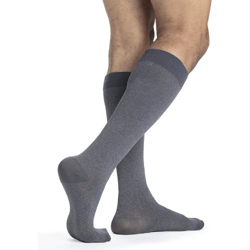 Male wearing his Sigvaris Microfiber Pattern 20-30 mmHg compression knee high in the design graphite heather.