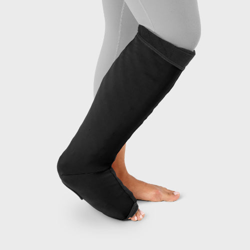 Person wearing their sleep sleeve over the Solaris Tribute below knee wrap in the color black.