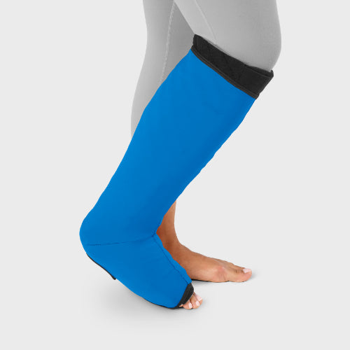 Person wearing their sleep sleeve over the Solaris Tribute below knee wrap in the color blue.