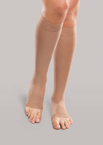 Lady wearing her Therafirm EASE Opaque Unisex Open Toe knee high 15-20 mmHg compression stockings in the color sand