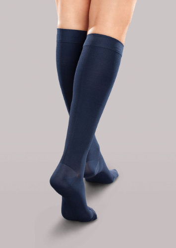 Lady wearing her Therafirm EASE Opaque Women's knee high 15-20 mmHg compression stockings in the color navy