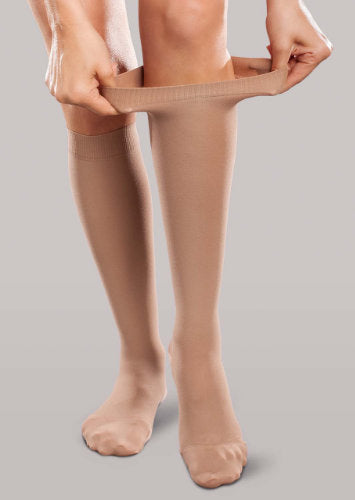 Lady showing how stretchy her Therafirm Ease Opaque compression stockings are by pulling at the top band
