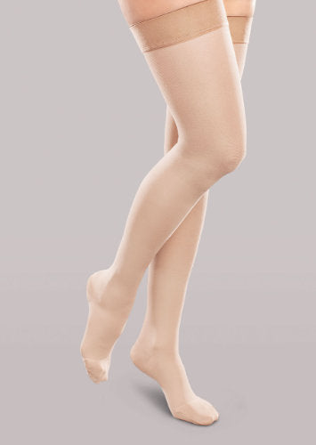 Lady wearing her Therafirm EASE Opaque Women's thigh high 15-20 mmHg compression stockings in the color natural