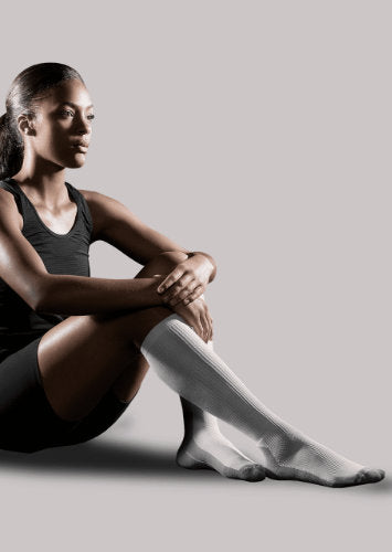 Woman wearing her Therasport Athletic Recovery Compression Socks in the color white.