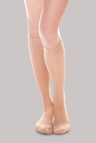 Lady wearing her Ease Sheer 20-30 mmHg compression stocking by Therafirm in the color sand.