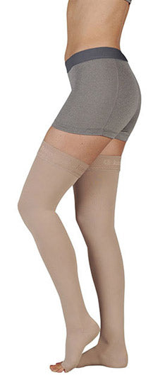 Lady wearing her Juzo Soft Thigh High Open Toe 30-40 mmHg Compression Stockings in the color beige