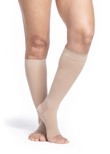 Female leg wearing Sigvaris 782CO Sheer Open Toe Knee High Compression Stockings in the color Honey