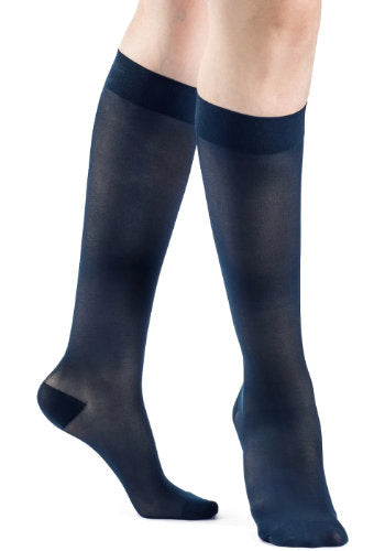 Female legs wearing Sigvaris 783 Sheer Knee High Compression Stockings in the color Dark Navy