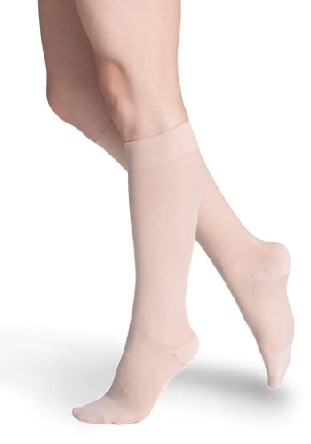 Female legs wearing Sigvaris 782 Sheer Knee High Compression Stockings in the color Warm Sand