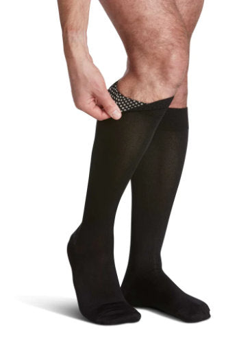 Guy showing the silicone dot band of his Sigvaris Microfiber 822C/S compression socks in the color black