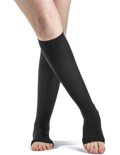 Lady wearing her open-toe 841CO Sigvaris Soft Opaque Compression Stockings in the color Black