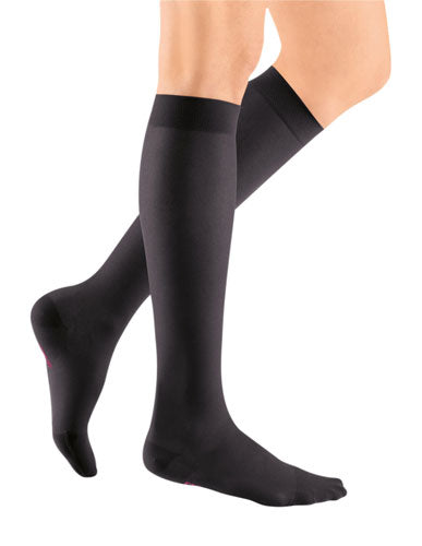 Lady wearing her Mediven Sheer & Soft Closed Toe Knee High 20-30 mmHg Compression Stocking in the color Ebony