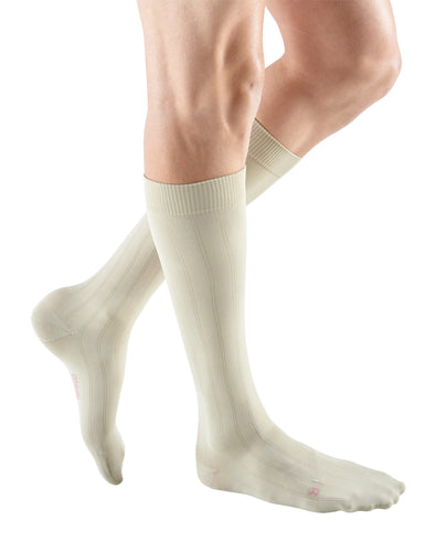 man wearing a pair of tan knee-high compression socks the Mediven for Men Classic sock has a thin verticle pinstripe design