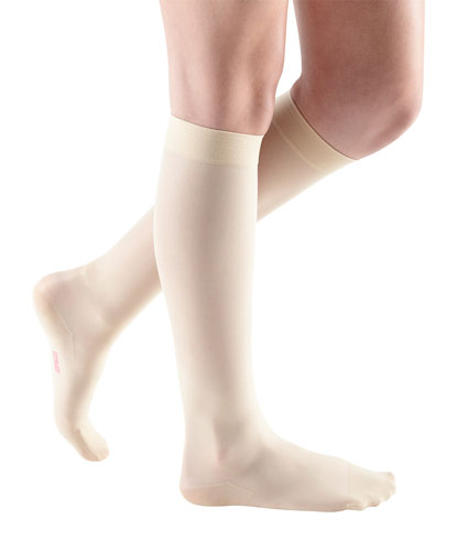 Lady wearing her Mediven Sheer & Soft Closed Toe Knee High 20-30 mmHg Compression Stocking in the color Wheat