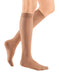 Lady wearing her Mediven Sheer & Soft Closed Toe Knee High 20-30 mmHg Compression Stocking  in the color Natural